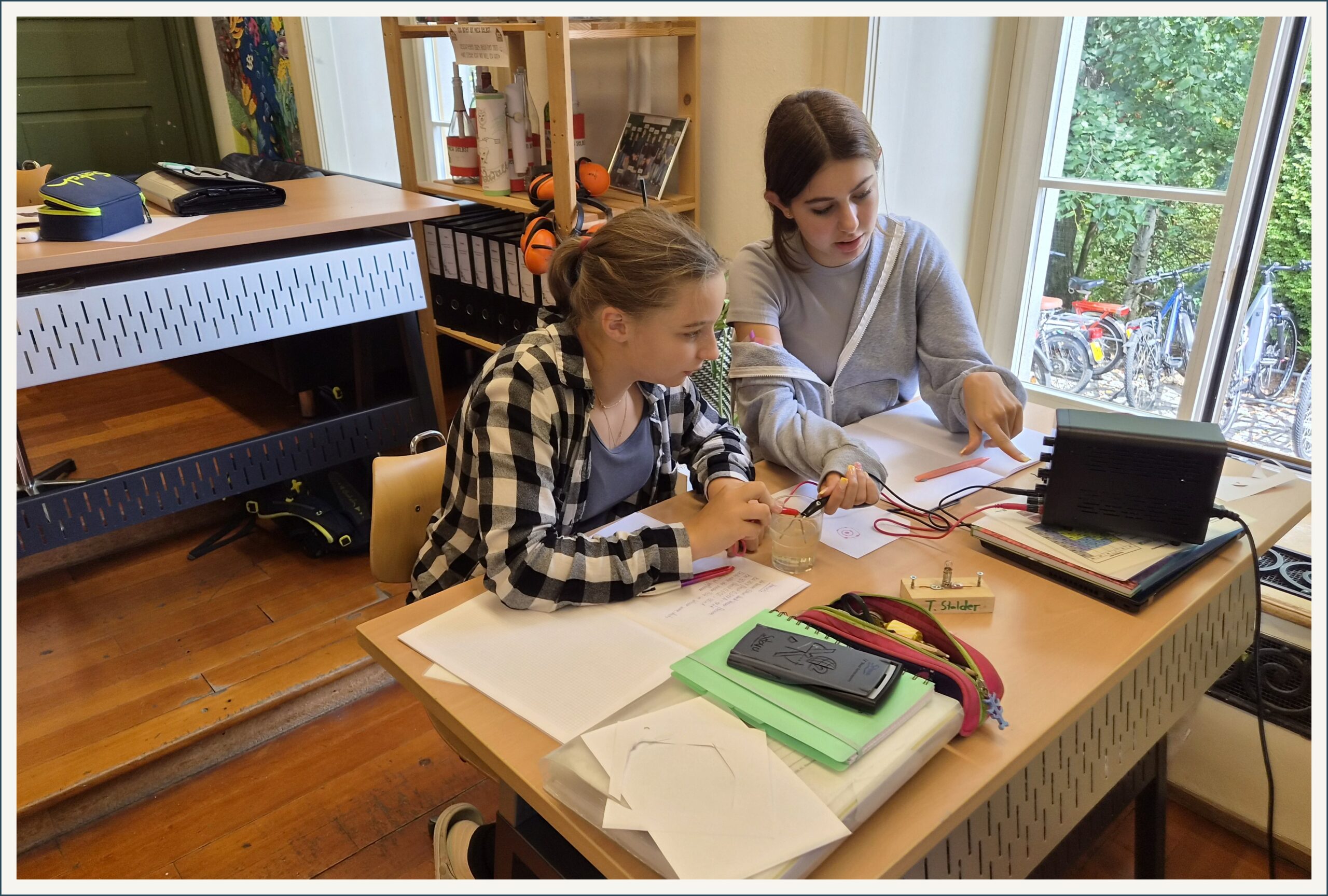 Schülerinnen und Schüler experimentieren am Tisch